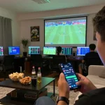 Engaging scene showcasing Ty le keo nha cai being explored on a smartphone during live sports betting at home.