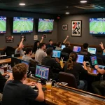 TG88 players enjoying real-time sports betting in an energetic lounge filled with screens and excitement