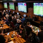 Experience cm88 sports betting excitement in a lively bar with live events on screens.