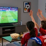 رابط مشاهدة مباريات اليوم بدون تقطيع in an exciting living room atmosphere with fans cheering for their favorite teams during a live game.